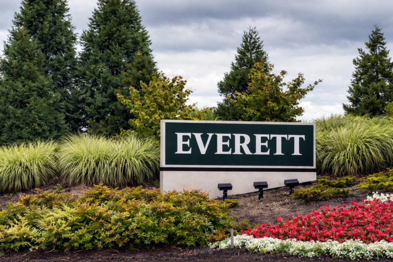 Everett, WA city sign surrounded by landscaped greenery and trees